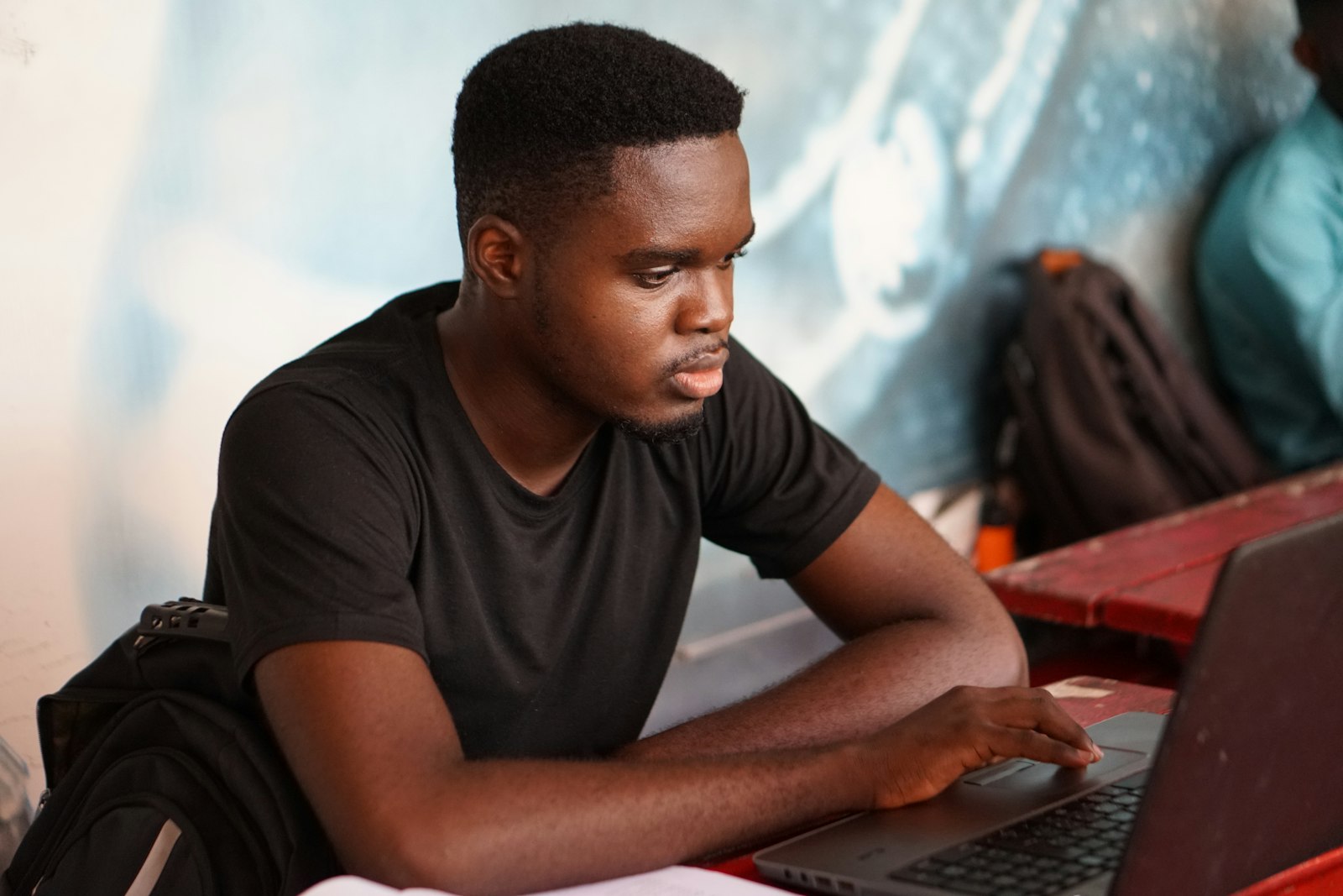 A young developer focused on code at his laptop